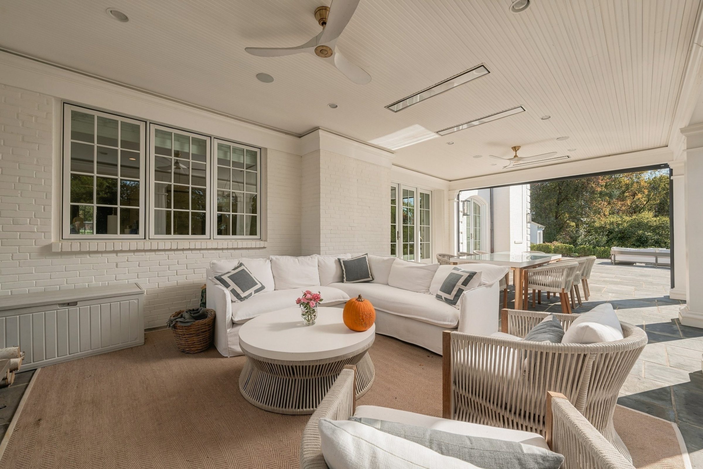 Screened porch lounge opening to the stone terrace