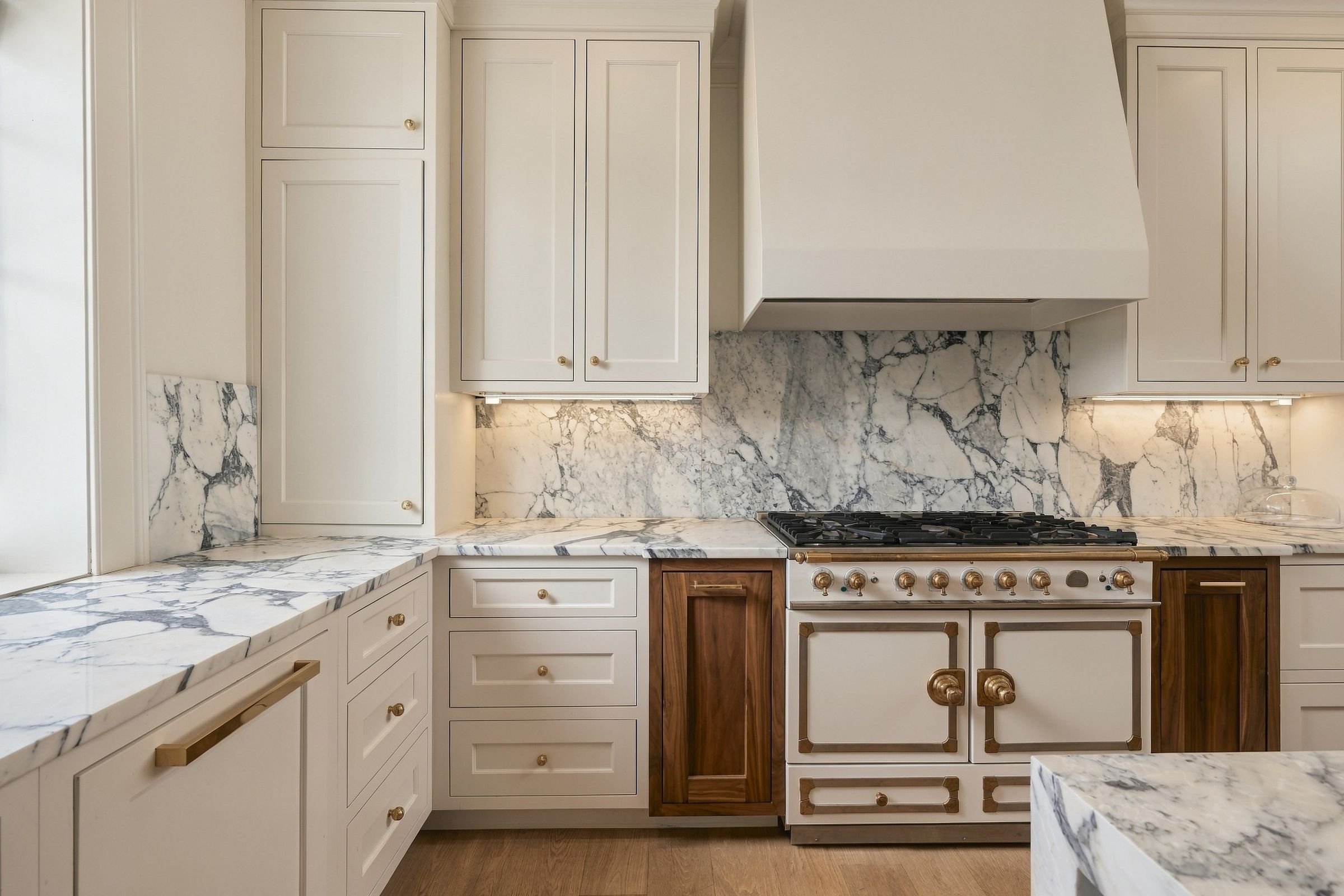 La Cornue range beneath a custom hood and marble backsplash